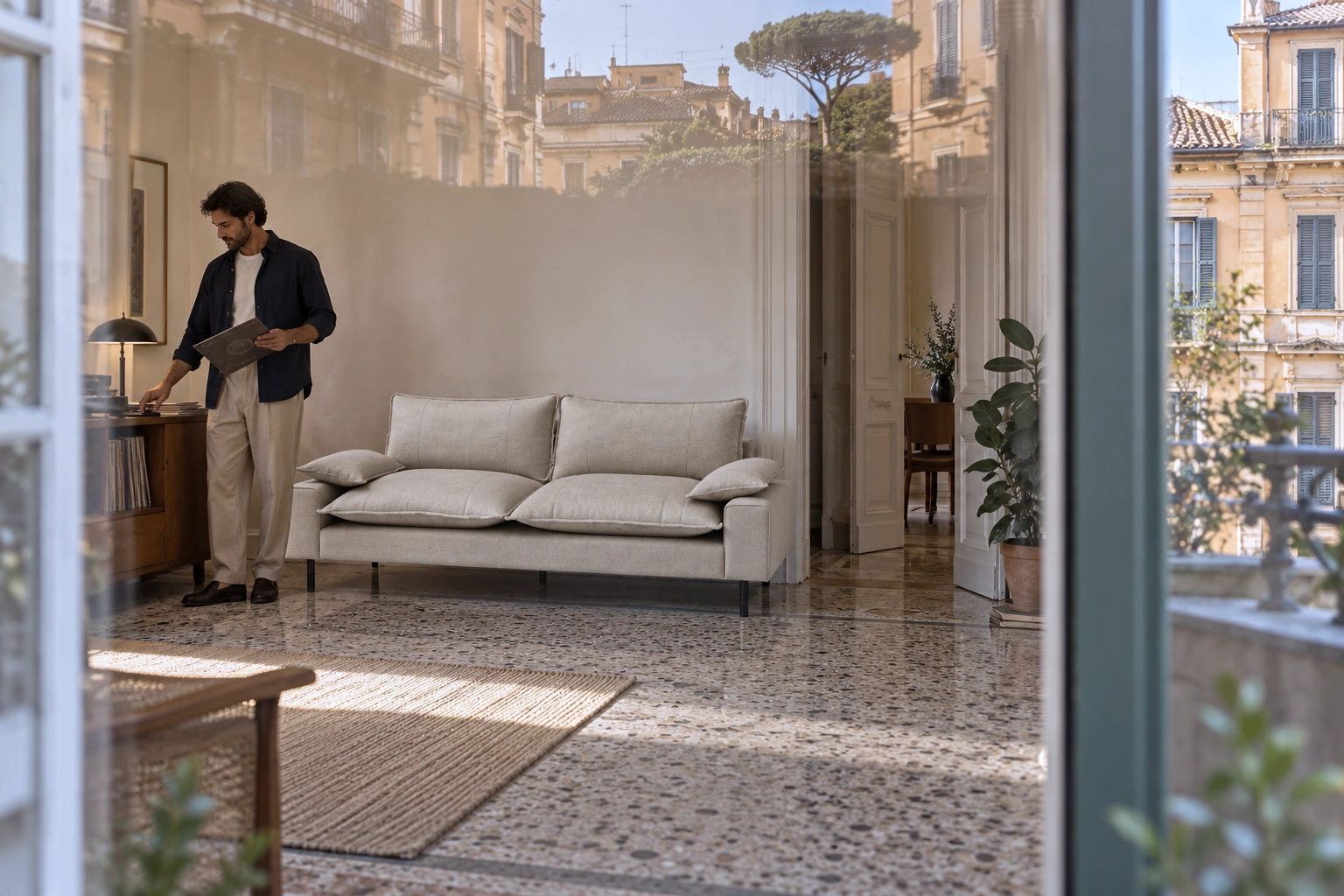 AVENTINE sofa in a Roman interior; a man chooses a record, with city facades reflected in the glass