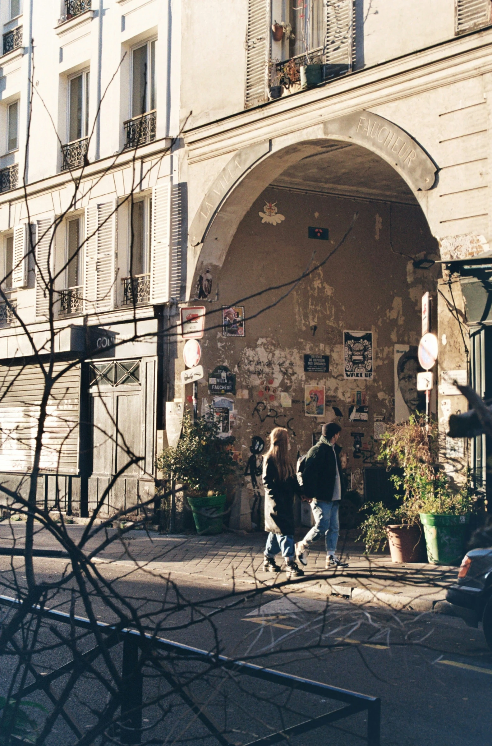 A meeting beneath an arch in a Parisian courtyard.