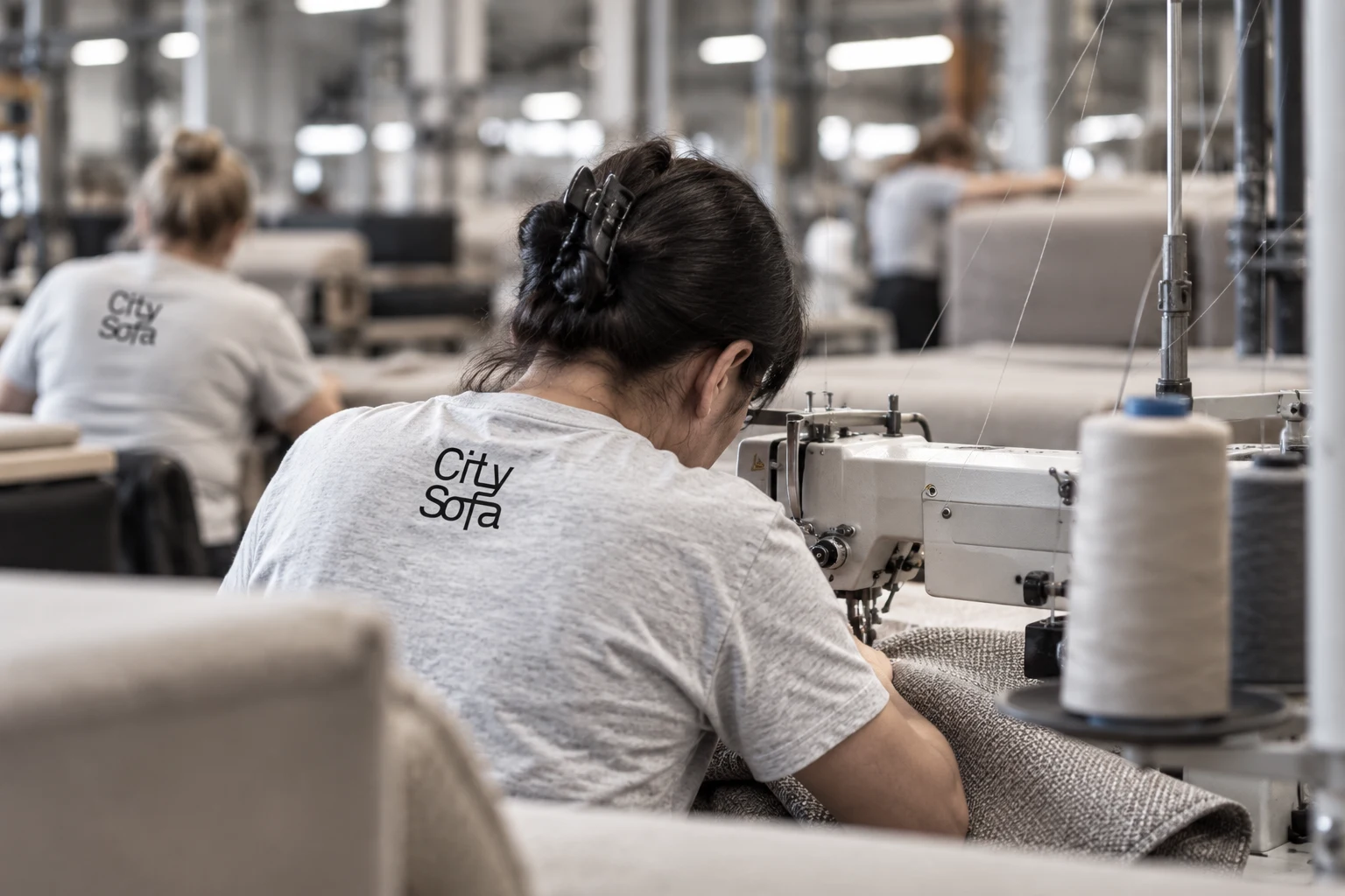 A City Sofa employee sewing upholstery at the factory